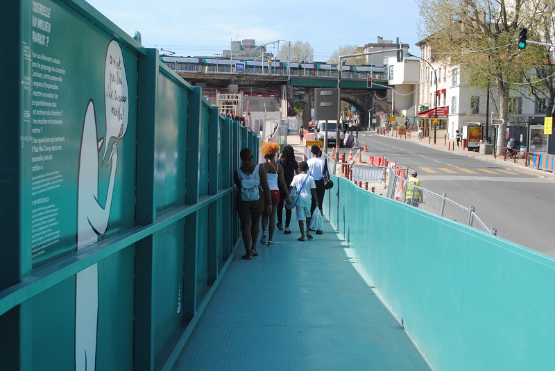 Un groupe de participants traverse une passerelle bleue dans le cadre du chantier partagé avec Yes We Camp