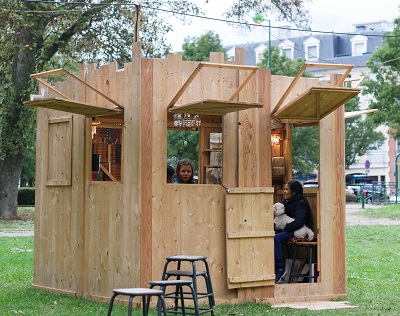 Plusieurs participants à l’intérieur d’un des cabinets en bois dans le cadre du spectacle « Palissades » de la Compagnie Le Phun à Sevran