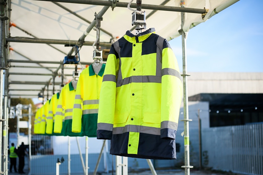 Zoom sur une série de vestes jaunes de chantier suspendues 