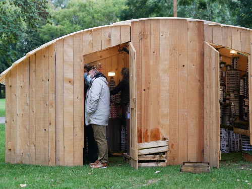 Plusieurs participants à l’intérieur d’un des cabinets en bois dans le cadre du spectacle « Palissades » de la Compagnie Le Phun à Sevran