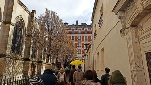 Un groupe de marcheurs de dos devant une église dans le cadre de la balade sonore aux abord des chantiers du Grand Paris Express d’Aubervilliers par la Compagnie Décor Sonore
