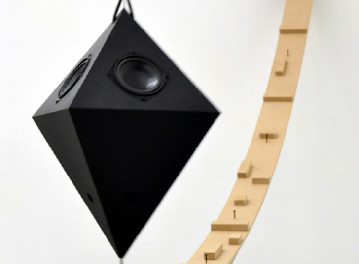 Arc en bois avec au-dessus une suspension en forme géométrique noire, installation issue de l’exposition collective « Hasard pendulaire » avec Mathias Isouard