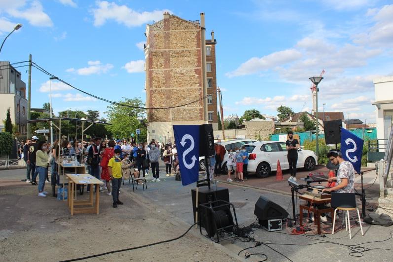 Public autour d’une buvette et d’un DJ en espace public lors d’un évènement festif le aux abords du chantier de la future gare de Fort d’Issy-Vanves-Clamart-Malakoff dans le cadre du chantier partagé « Détours » mené par les collectifs Beat and Beer et Crème Fraîche