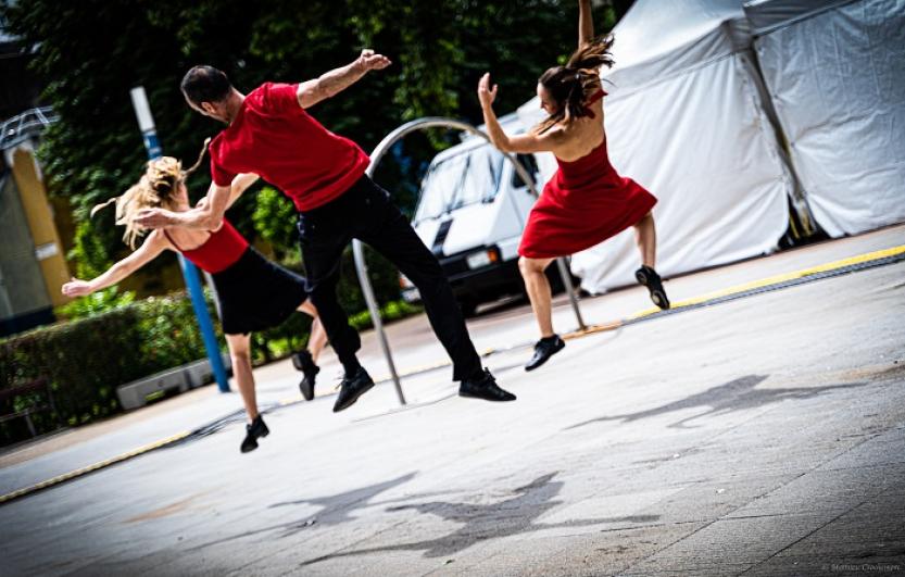 Trois danseurs en rouge et noir dansent devant l’arrêt de métro Fort d’Aubervilliers pendant l’AuberJazz Day