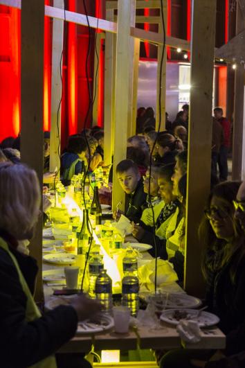 Le public en gilet jaune de chantier déguste autour d’une grande tablée un gigot bitume lors du KM2 à Arcueil – Cachan