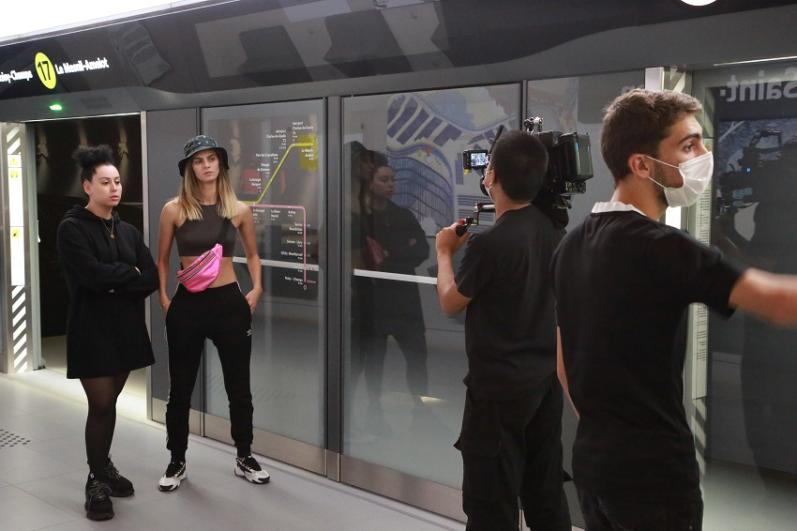 Quatre personnes tournent une scène sur une maquette à échelle 1 du futur quai de gare du Grand Paris Express, à la Fabrique du métro