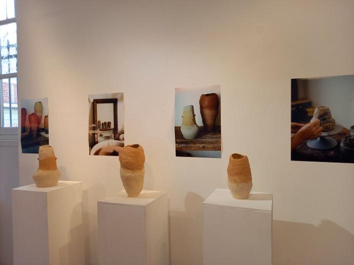 Zoom sur trois pots en terre issue des chantiers du Grand Paris Express avec deux photographes en arrière-plan
