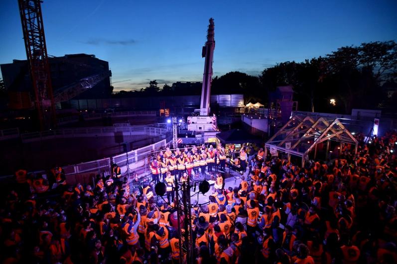 Une foule de public de nuit vers la grue sur le chantier à Massy dans le cadre du KM9