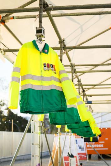 Zoom sur une série de vestes jaunes et vertes de chantier suspendues