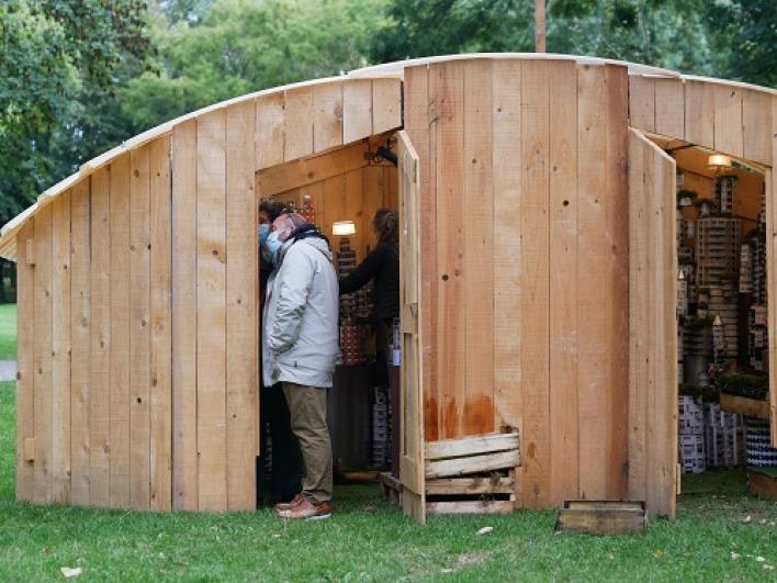 Plusieurs participants à l’intérieur d’un des cabinets en bois dans le cadre du spectacle « Palissades » de la Compagnie Le Phun à Sevran