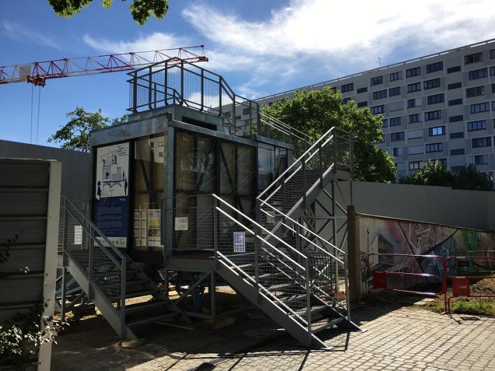 Belvédère en forme de maison des projets devant les palissades du chantier de Vitry-Centre