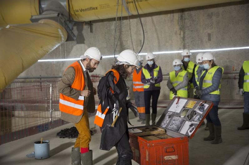 Deux comédiens en gilets de chantier orange avec en face le public en gilets de chantier jaunes dans le cadre du spectacle théâtralisé « Visite insolite de chantier » par la Compagnie Méliadès dans le chantier de l’entonnement Salengro à Champigny-sur-Marne en 2021